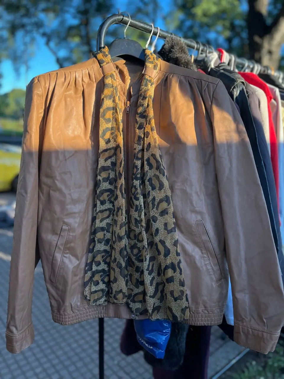 Campera de cuero marrón con detalle de bufanda con estampado de leopardo. Ideal para un look retro y canchero.