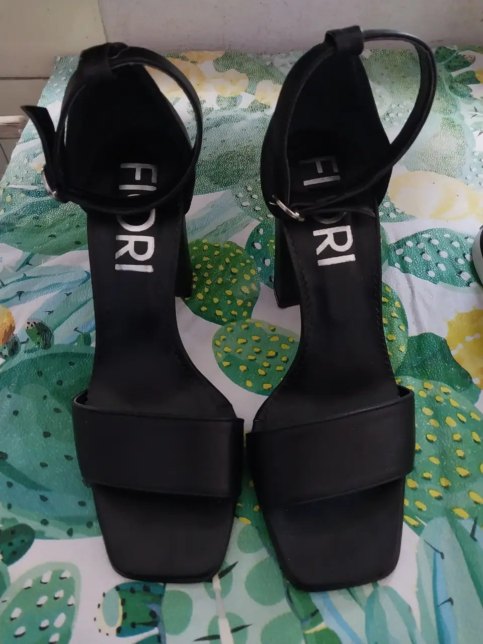 Sandalias de taco alto negras de la marca Fiori, con pulsera en el tobillo y detalle de hebilla. Talle 36, hechas en Argentina con cuero legítimo.