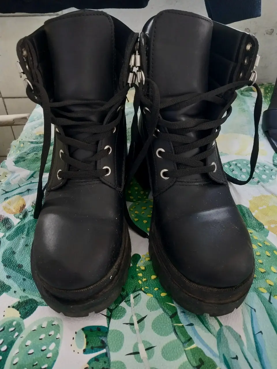 Borcegos negros de cuero sintético con cordones y suela gruesa. Ideales para un look urbano y moderno.