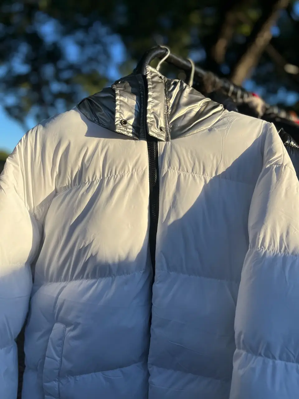 Campera puffer blanca con capucha plateada. Ideal para el invierno, abrigada y con cierre.