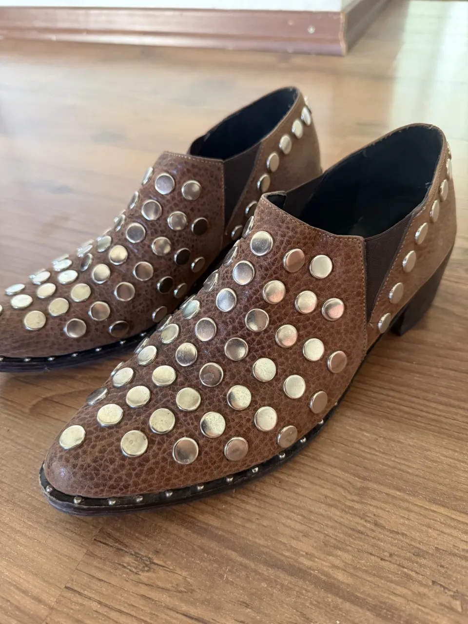 Botitas de cuero marrón con tachas plateadas. Un diseño único y canchero para darle un toque rocker a tu look. Ideales para el día a día o para una salida.
detalle en taco derecho 