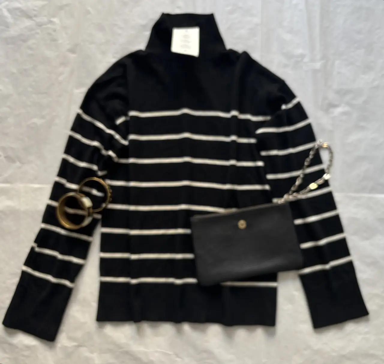 Sweater de cuello alto a rayas horizontales en negro y blanco. Ideal para un look casual y moderno. Confeccionado con materiales reciclados.