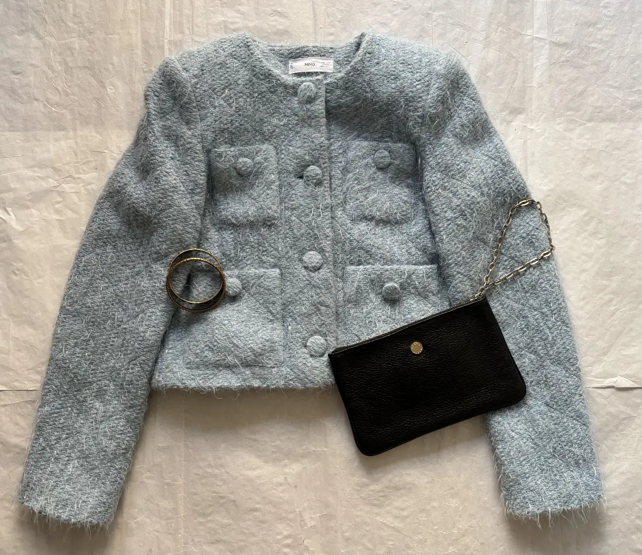 Chaqueta de mujer celeste, estilo tweed, con botones y bolsillos. Ideal para un look elegante y sofisticado.
