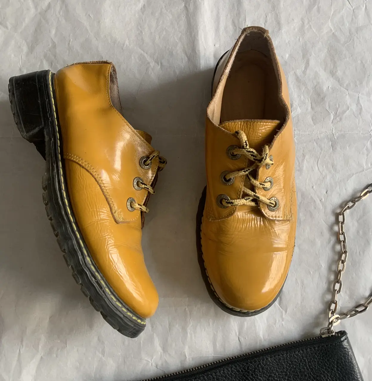 Botines amarillos de cuero charolado con cordones y suela gruesa. Estilo vintage, ideales para un look retro.