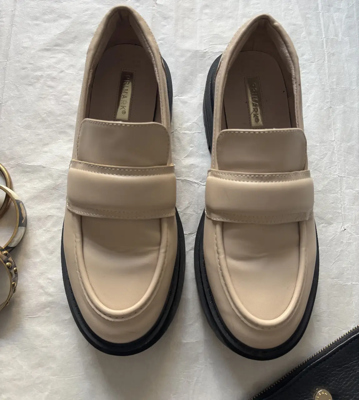 Mocasines de mujer color crema con suela negra. Estilo moderno y cómodo, ideales para un look casual y versátil.