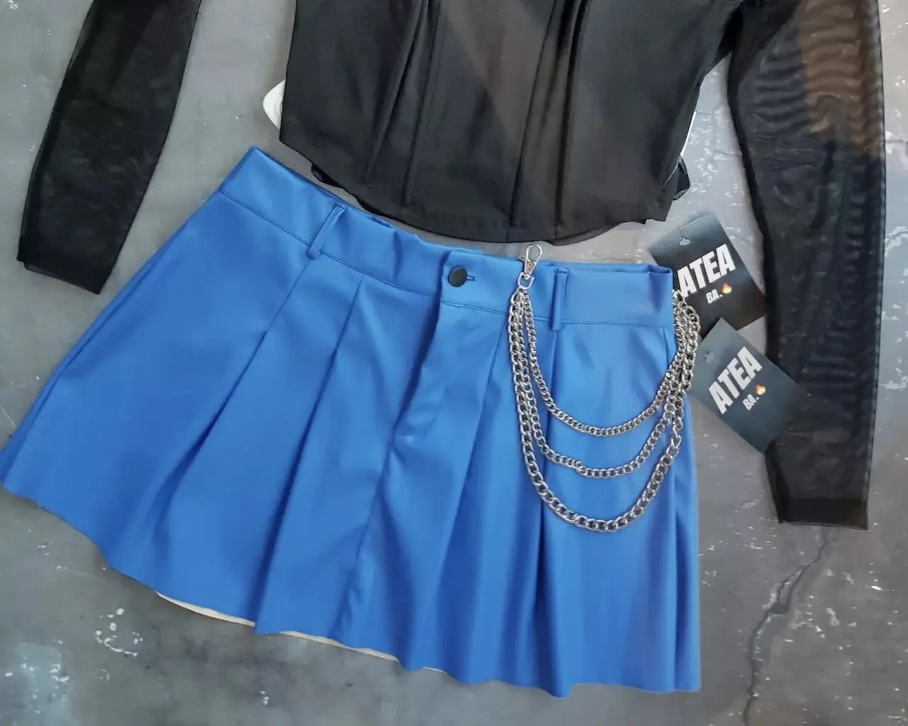 Minifalda tableada azul con detalle de cadena. Ideal para un look moderno y audaz. es un talle M/L
