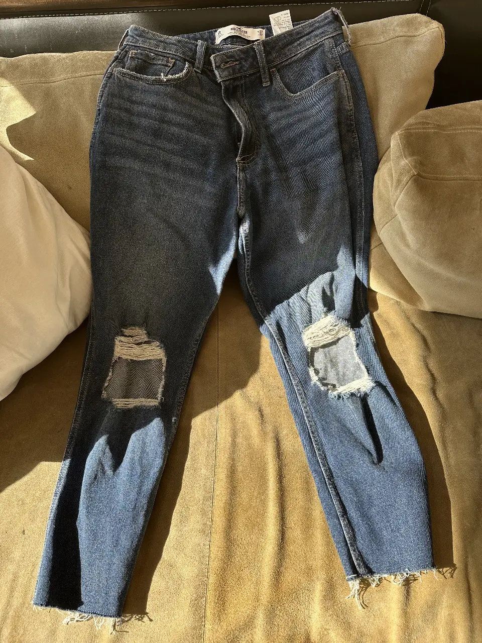 Jeans de mujer, tiro alto, con roturas en las rodillas. Corte recto y con el bajo desflecado. Ideal para un look casual y moderno.