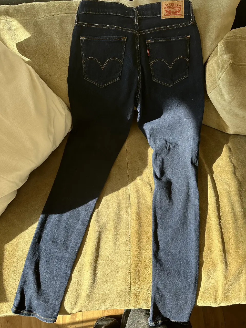 Jeans rectos de mujer, color azul oscuro, con el clásico diseño de bolsillos traseros de Levi's. Ideal para un look casual y versátil.