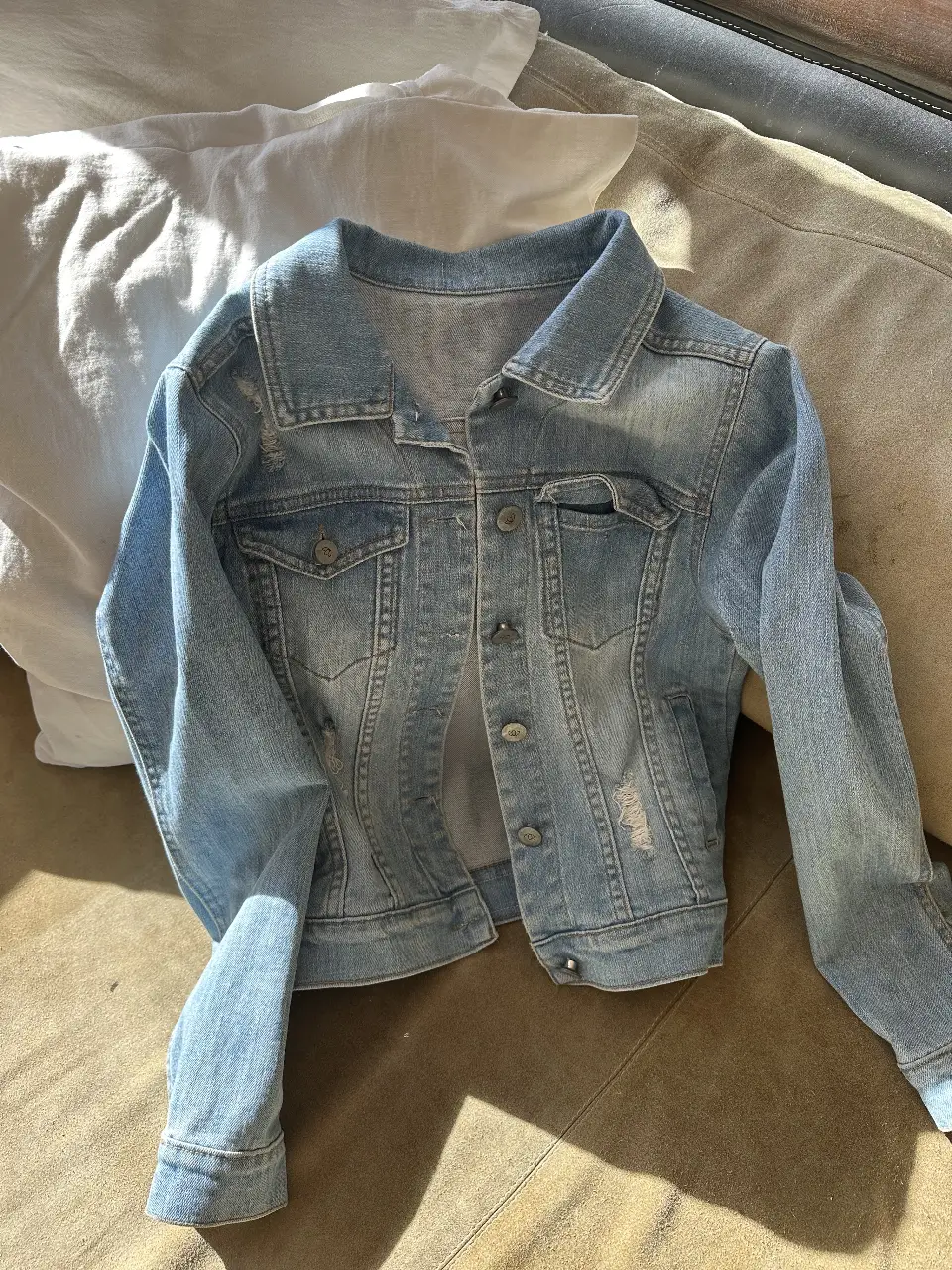 Campera de jean azul claro con detalles de roturas y desgaste. Ideal para un look casual y canchero. Talle 32 