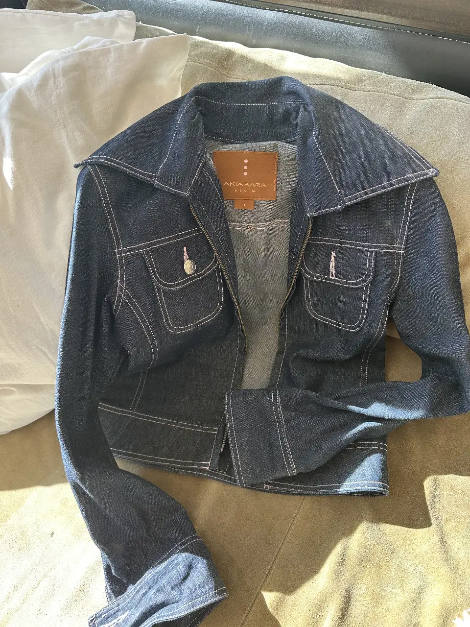 Campera de jean azul oscuro con costuras blancas. Corte entallado, con bolsillos delanteros y cuello solapa. Ideal para un look casual y canchero.