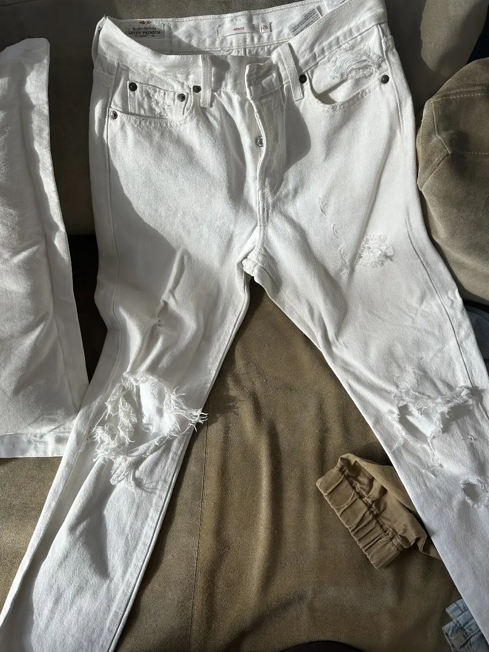 Jeans blancos rotos de mujer, tiro alto, con detalles de roturas en las rodillas y desgaste en los bordes. Un clásico para un look casual y moderno.