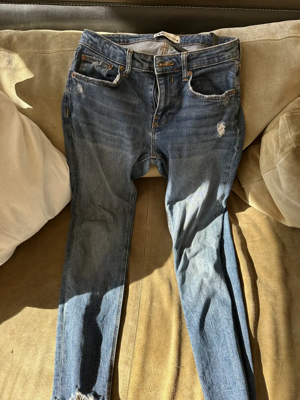 Jeans de mujer, tiro medio, con roturas en las rodillas y flecos en el bajo. Marca Zara.