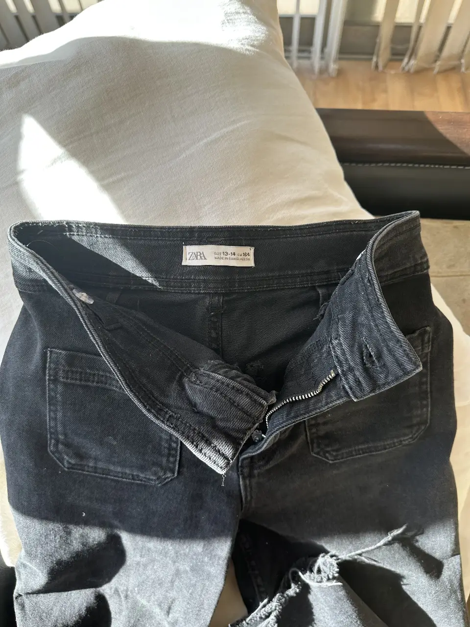 Jeans negro de mujer, con roturas en la parte inferior de la pierna. Tiro alto, con bolsillos delanteros y traseros. Marca Zara. 13 /14 niña tiro alto