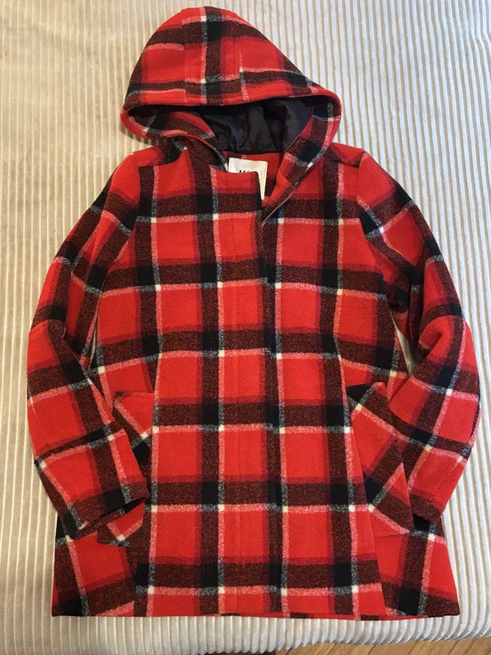 Tapado con capucha a cuadros rojos y negros, ideal para el invierno. Posee bolsillos y un diseño clásico de abrigo que abre con cierre reforzado . Todo forrado . 