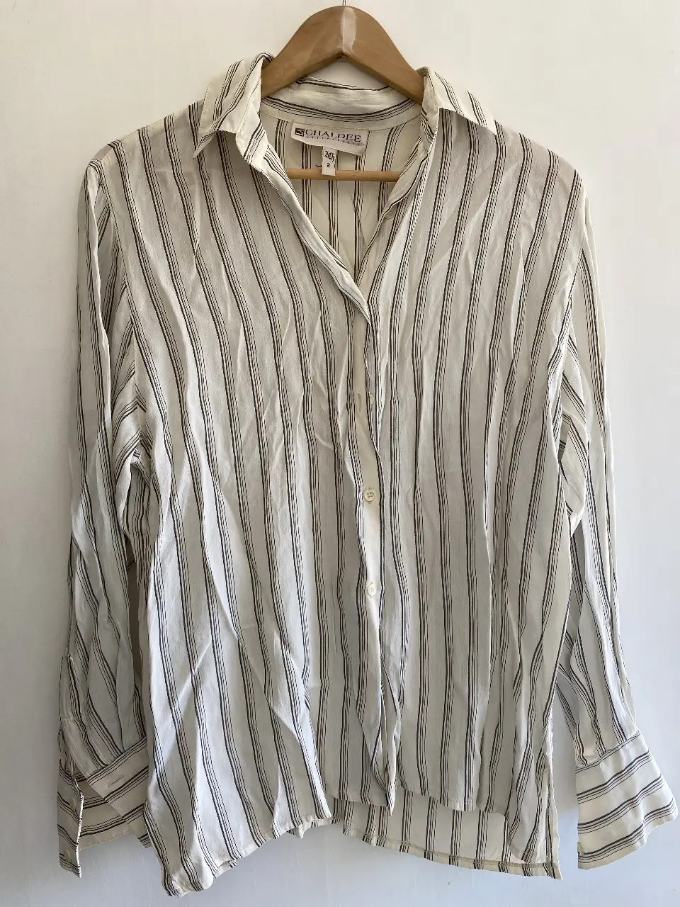 Camisa a rayas verticales en blanco y marrón, con cuello clásico y botones. Ideal para un look casual o de trabajo.