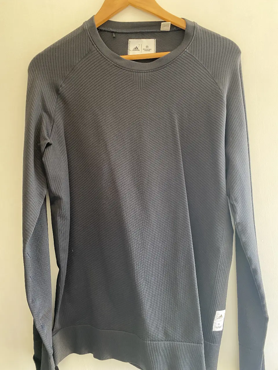 Buzo de cuello redondo Adidas, color gris oscuro, con diseño texturizado. Ideal para un look casual y cómodo.