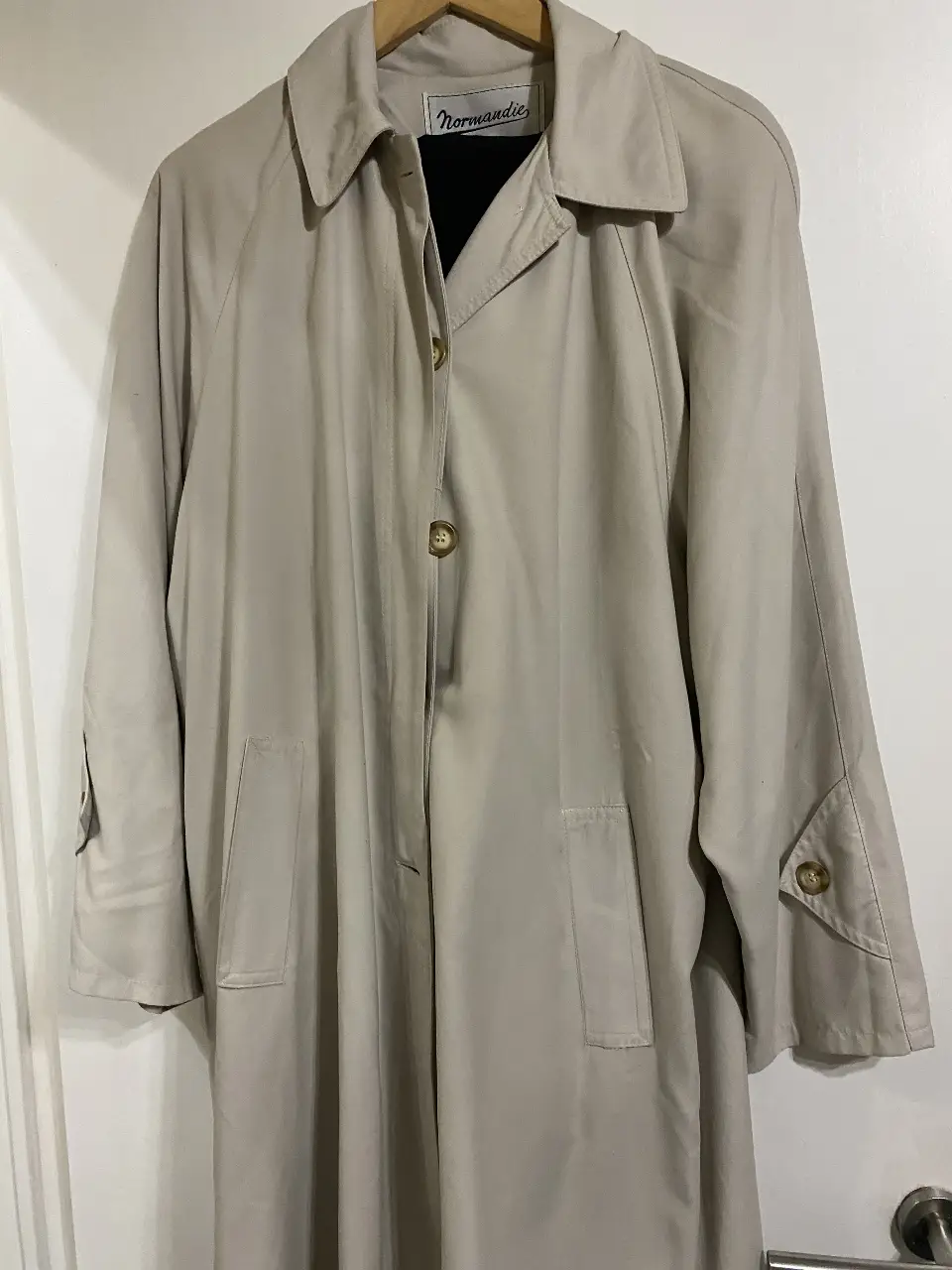 Trench coat beige de la marca Normandie, ideal para el invierno. Posee botones y bolsillos.