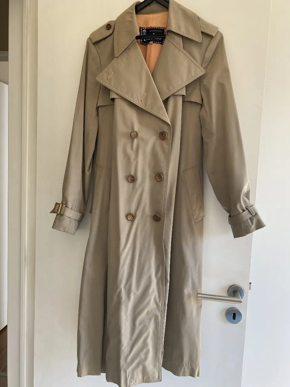 Trench coat clásico de color khaki, ideal para el entretiempo. Confeccionado en gabardina, doble botonadura y cinturón para ajustar la cintura. Un básico atemporal para cualquier guardarropa.