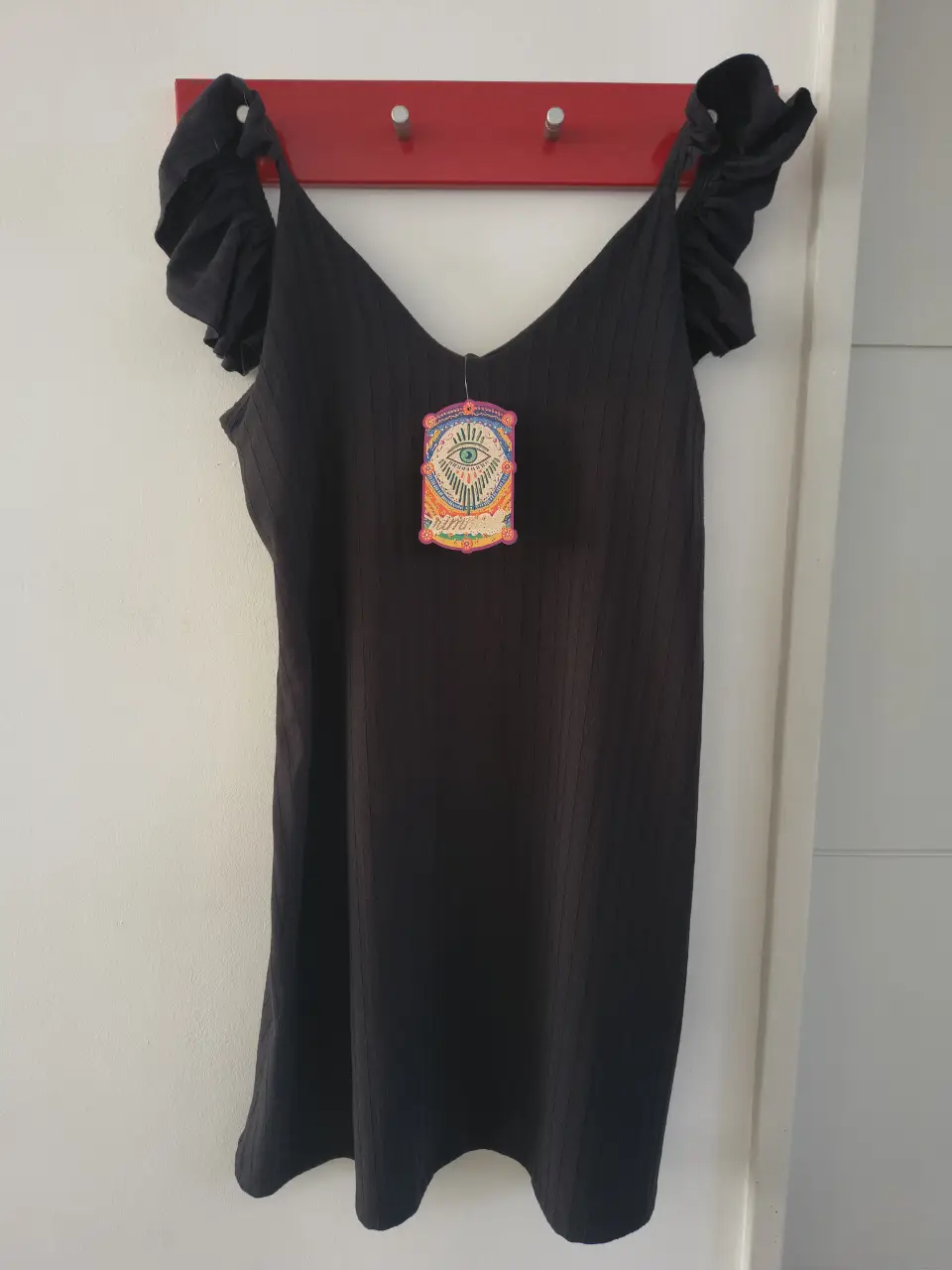 Vestido corto negro con breteles y volados en los hombros. Ideal para una salida casual o una fiesta.