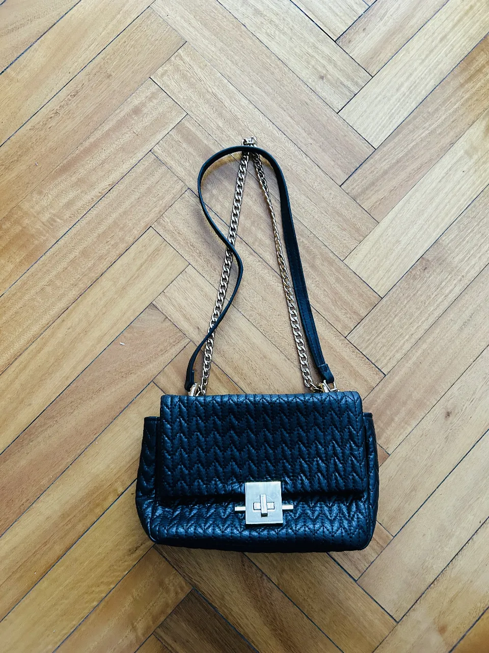 Cartera negra Goodluck Trolls con diseño acolchado. Posee cadena dorada y cierre metálico. 
