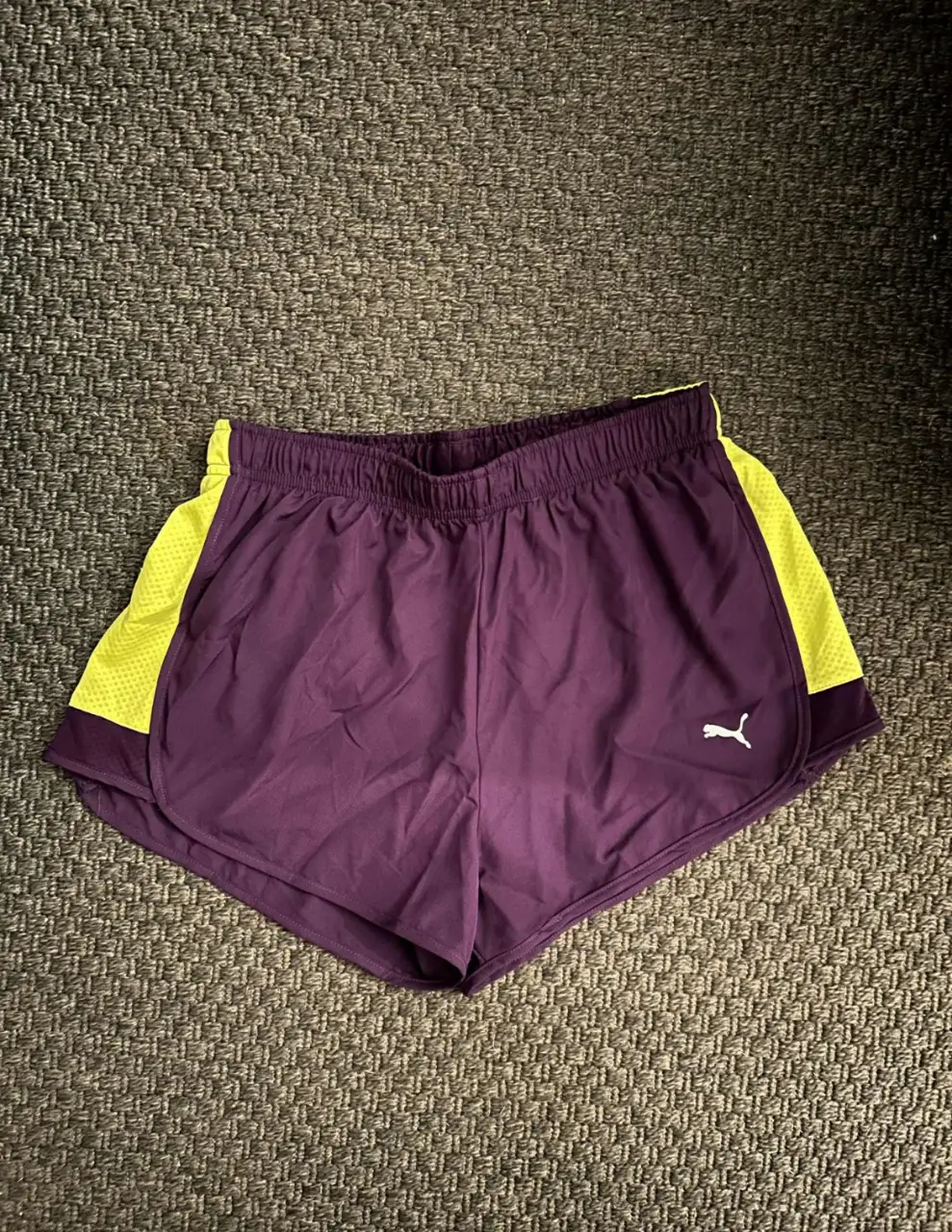 Short deportivo Puma para mujer, color violeta con detalles en amarillo. Cuenta con el logo de la marca y tecnología Cool Cell.