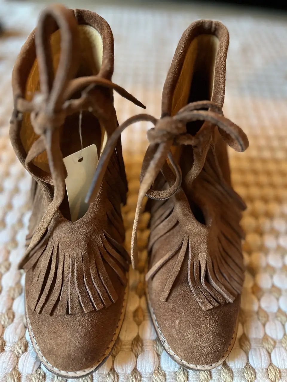 Botines de gamuza marrón con flecos y cordones. Ideales para un look boho o casual.