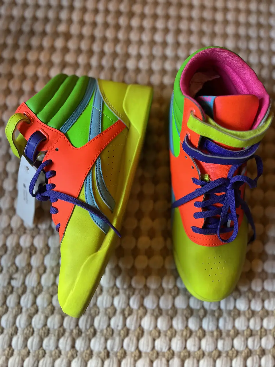 Zapatillas Reebok retro de caña alta, con detalles en amarillo fluo, naranja, verde, azul y rosa. Estilo vibrante y llamativo, ideales para un look urbano y deportivo.