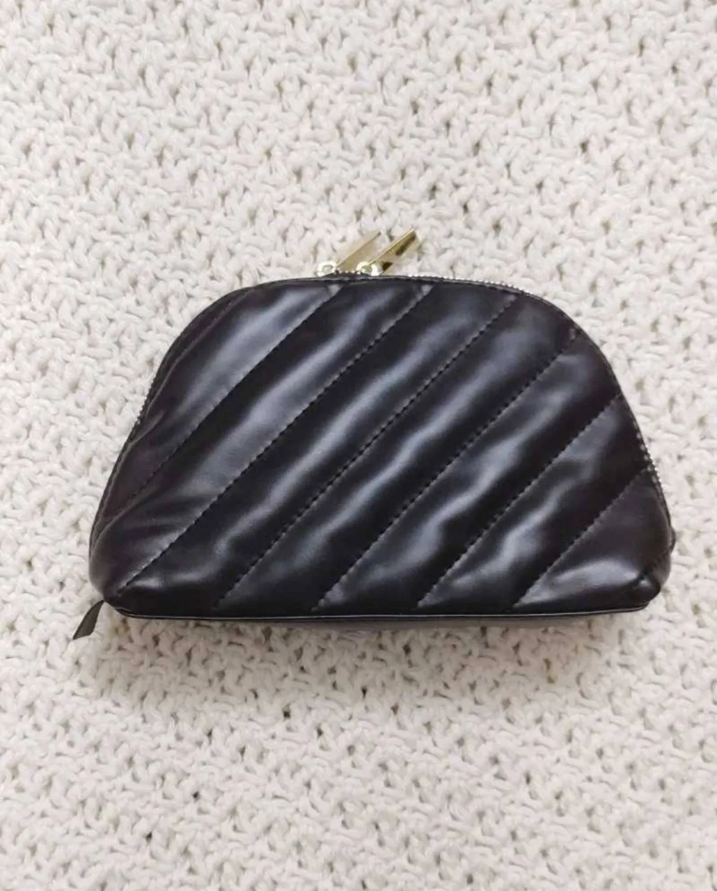 Neceser negro matelaseado con cierre dorado y logo de YSL Beauté. Interior forrado en negro con compartimentos. Cuero sintético.
20x13cm aprox