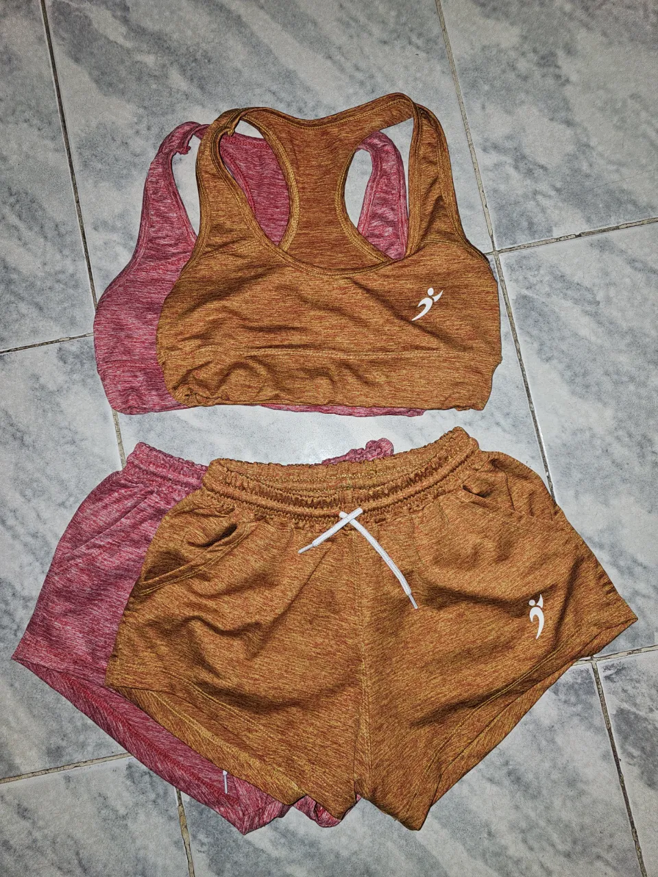 Conjunto deportivo para mujer, incluye top y short.  color rosa y  naranja, ambos con detalles deportivos.