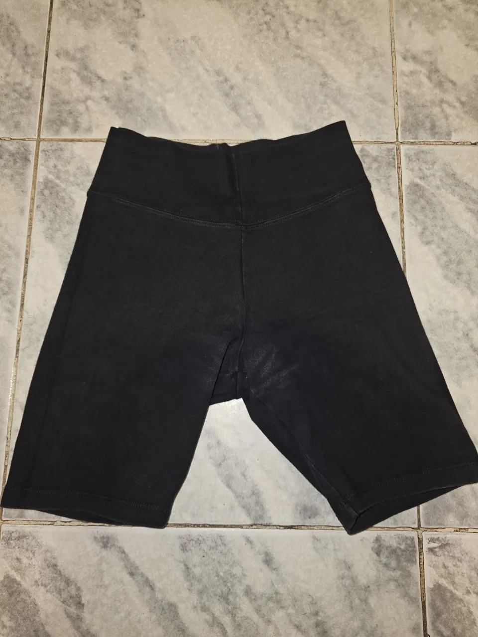 Short deportivo de mujer, negro, tiro alto, ideal para entrenamientos y actividades físicas. Cómodo y versátil.