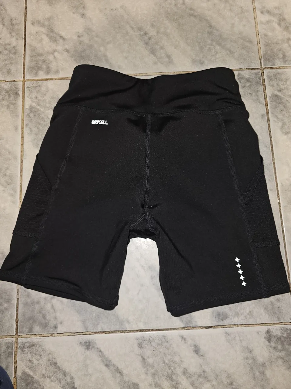 Short deportivo negro para mujer, ideal para actividades físicas. Confeccionado con tejido Drycell para mayor comodidad y rendimiento. Diseño moderno y funcional.