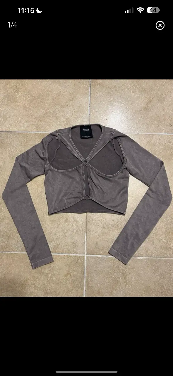 Top manga larga de Bershka, color gris. Diseño con aberturas y detalle de nudo en el frente. Ideal para un look moderno y audaz.