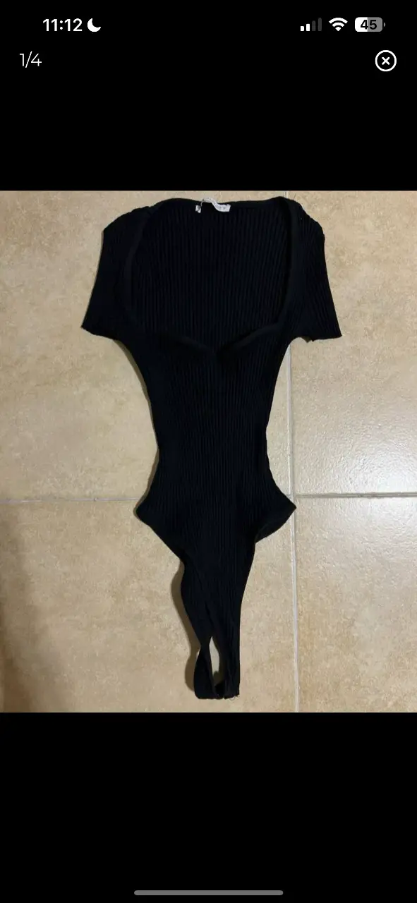 Body negro de tejido de punto con escote en V y corte en la cintura. Ideal para un look moderno y elegante.