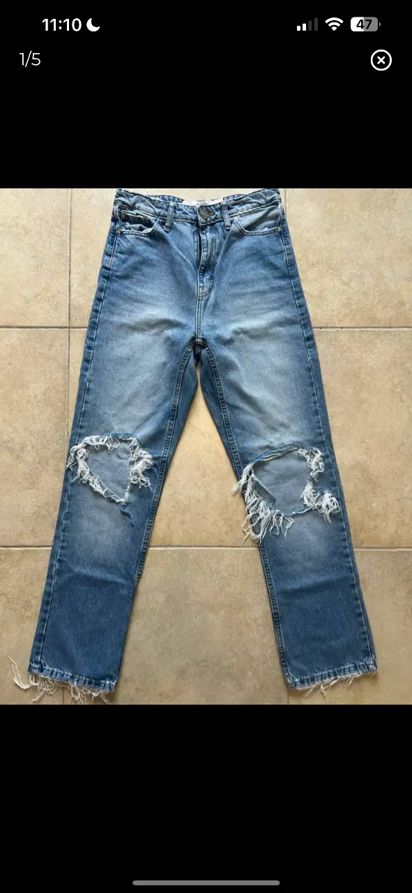 Jeans de mujer con roturas en las rodillas. Tiro alto, corte recto y con detalles desflecados en los bajos. Marca Ginebra.