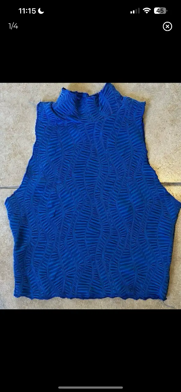 Top azul con cuello alto y textura ondulada. Ideal para un look moderno y audaz. Talle S.