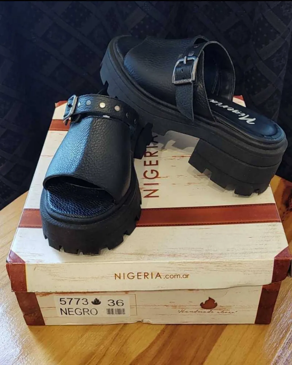 Sandalias negras cuero vacuno de plataforma con hebilla y detalles de tachas. Marca Nigeria, ideales para un look urbano y moderno.