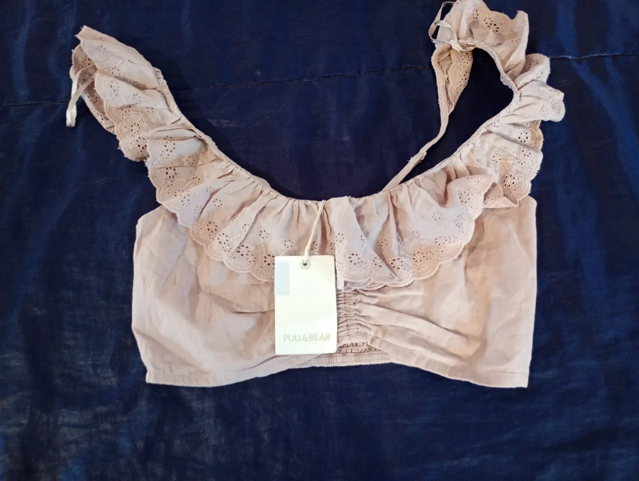 Top de mujer color crudo con volados y detalle de perforaciones. Ideal para un look fresco y femenino.