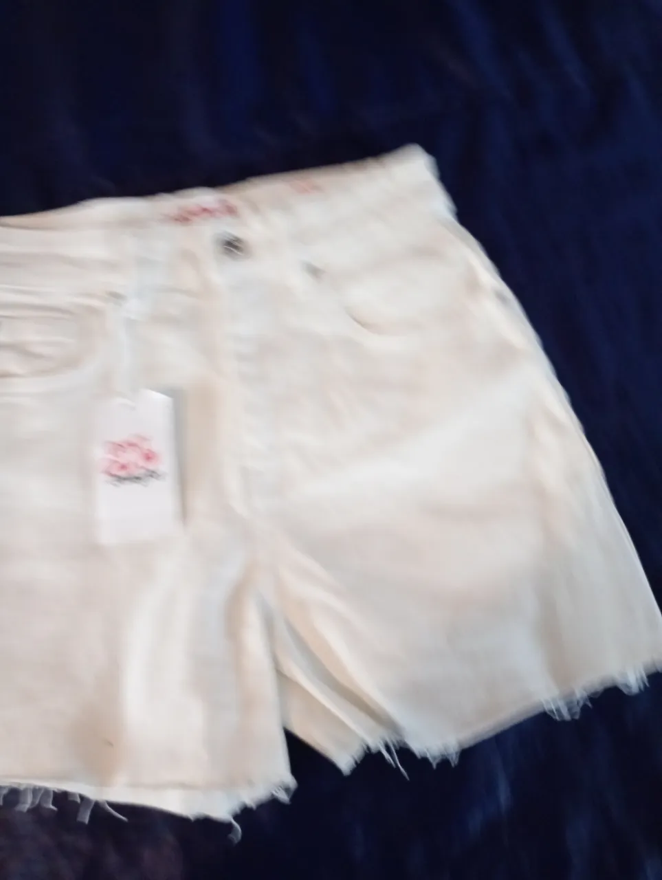 Short de jean blanco con detalles desflecados. Ideal para un look casual y fresco.