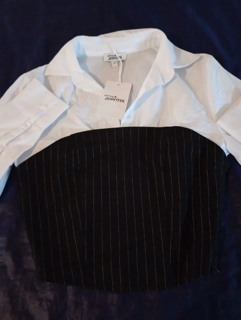 Camisa de mujer con diseño de rayas verticales en la parte inferior y cuello camisero. Ideal para un look elegante y moderno.