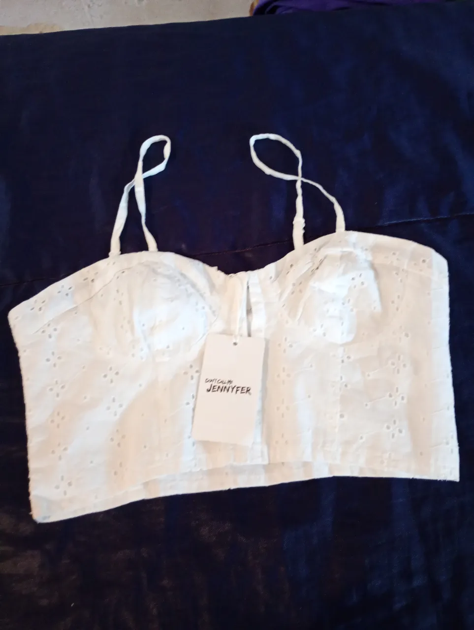 Top blanco de algodón con detalles calados y tirantes finos. Ideal para un look fresco y veraniego.