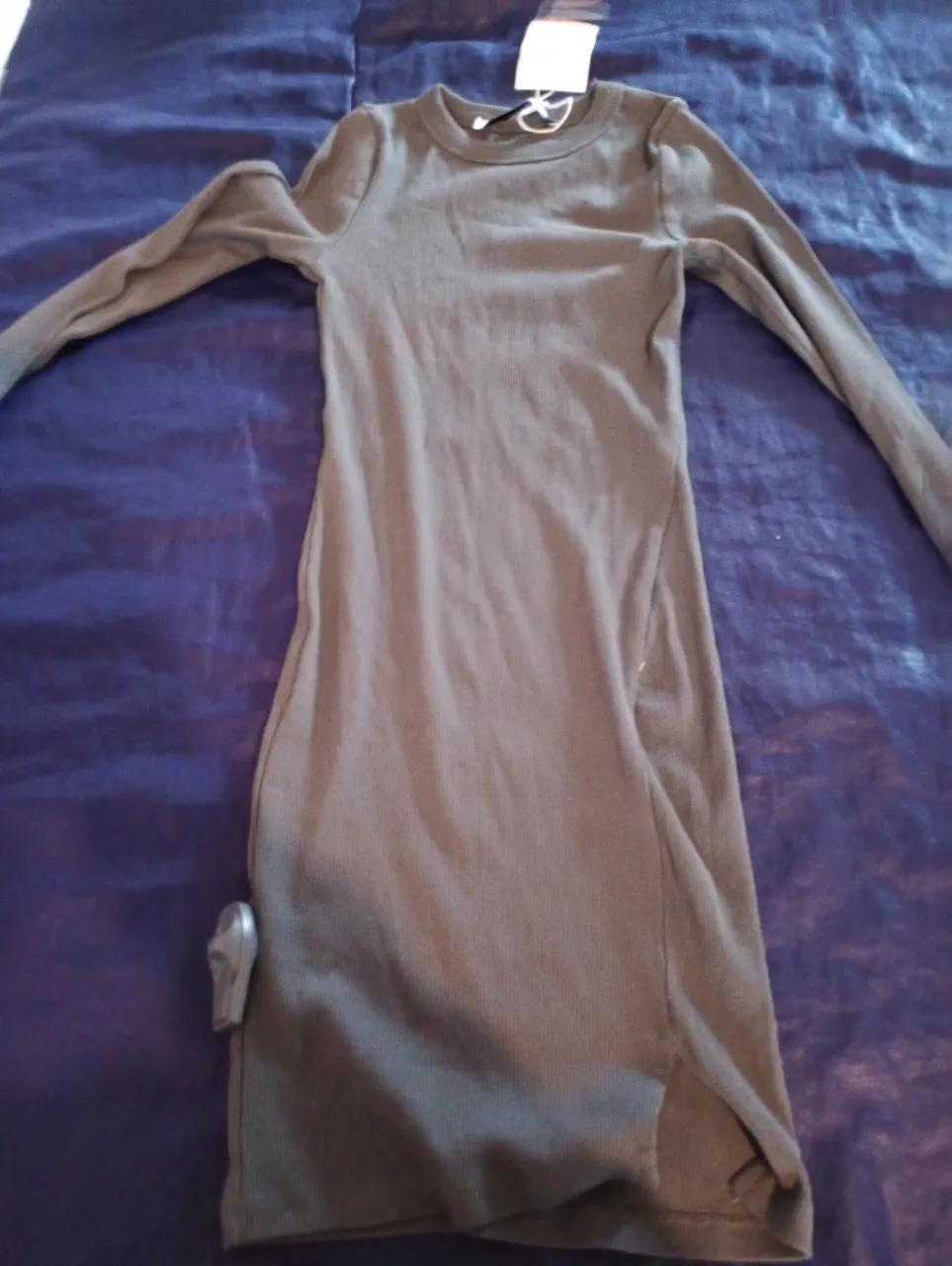 Vestido midi de manga larga en color gris, ideal para un look casual y cómodo. Confeccionado en tejido de punto suave y con un diseño simple pero elegante.