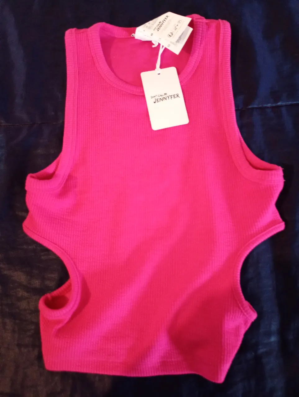 Top fucsia con aberturas laterales. Ideal para un look moderno y audaz. Perfecto para combinar con jeans o shorts.