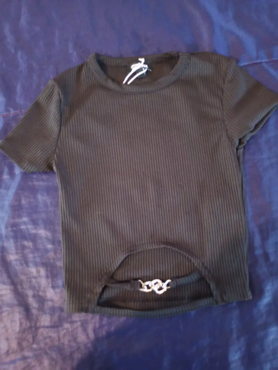 Top negro de corte ajustado con detalle de abertura en la espalda y cadena plateada. Ideal para un look moderno y audaz.