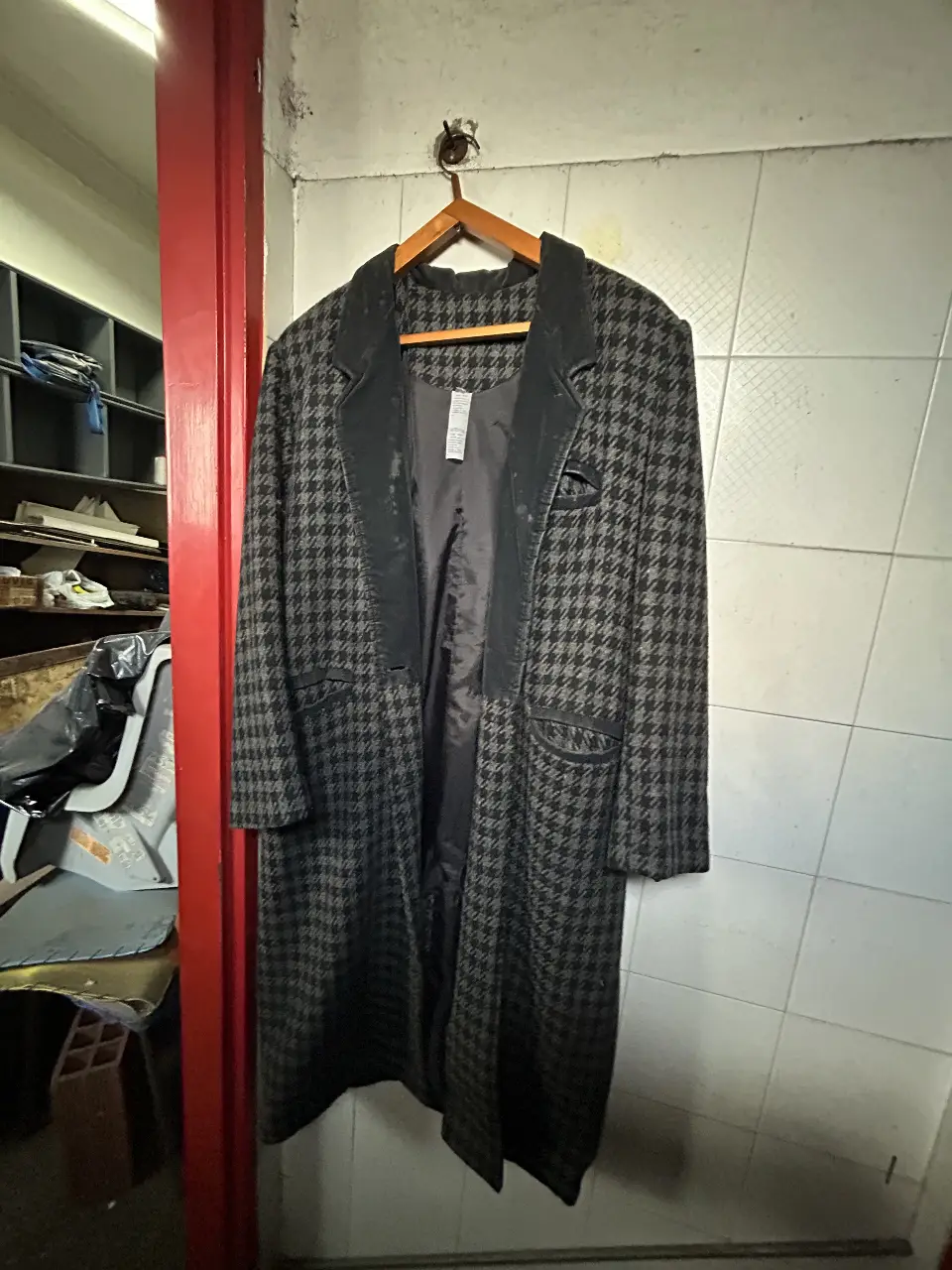 Tapado largo de mujer con estampado de pata de gallo en tonos grises y negros. Posee solapas de terciopelo negro y bolsillos. Ideal para un look elegante y abrigado.