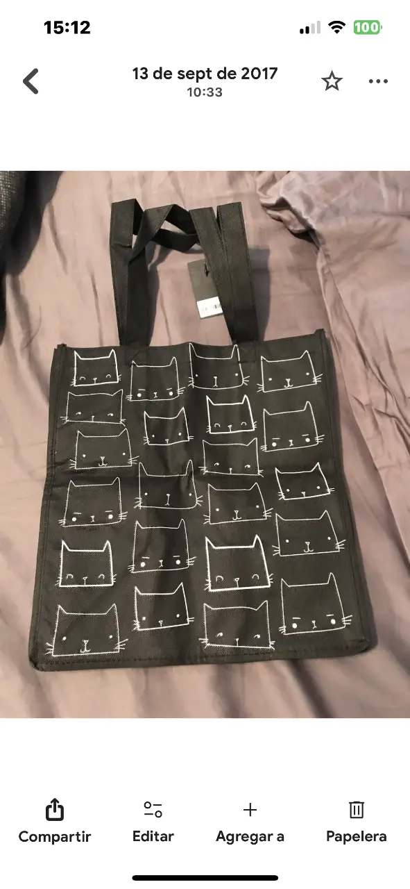 Bolso tote negro de tela con estampado de caras de gato en blanco. Ideal para llevar tus cosas con estilo y un toque divertido. Perfecto para el día a día.