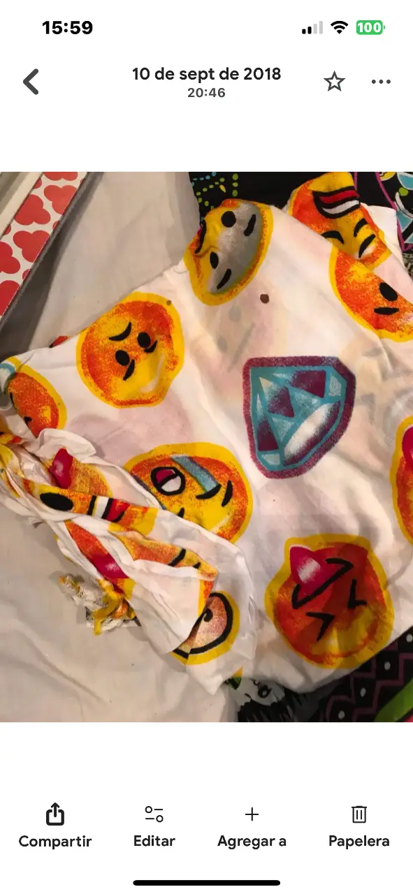 Camisa estampada con diseño de emojis y escudo. Ideal para un look casual y divertido.