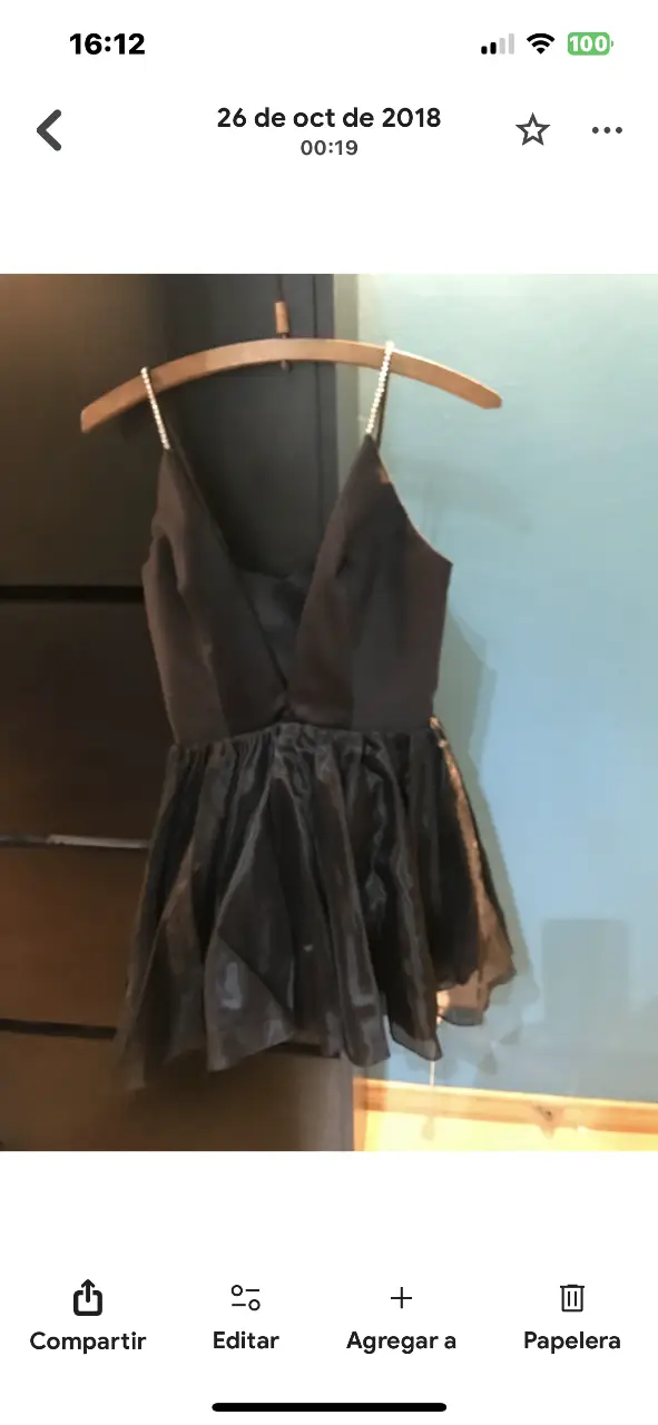 Vestido mini negro con tirantes finos adornados con detalles brillantes. Diseño elegante con escote en V y falda con vuelo, ideal para fiestas y eventos especiales.