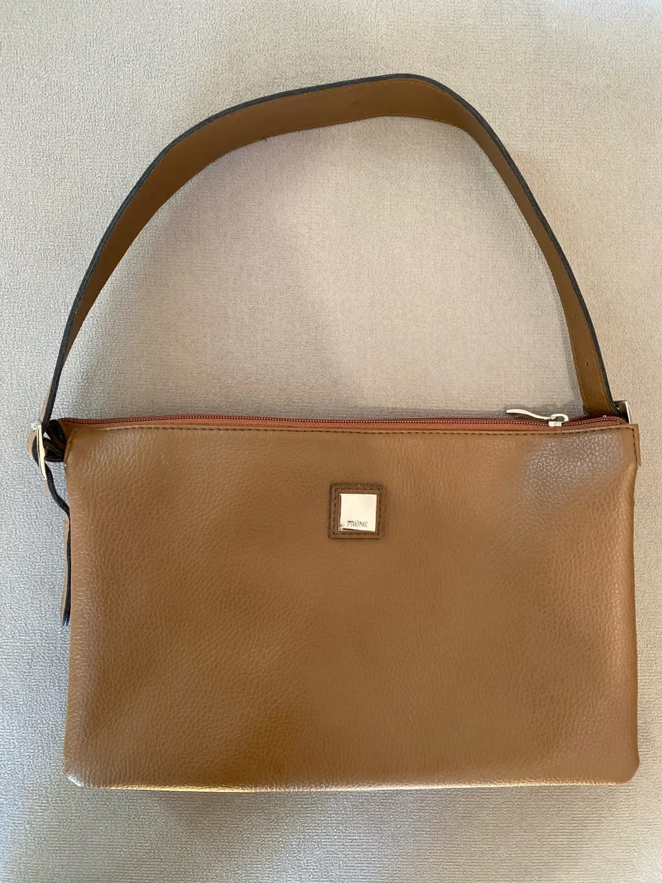 cartera prune color marron suela 
medida de 30 cm x 20 cm 
correa desmontable, de ambos lados, se puede usar como sobre 3 compartimientos internos + bolsillo interior excelente estado, sin detalles