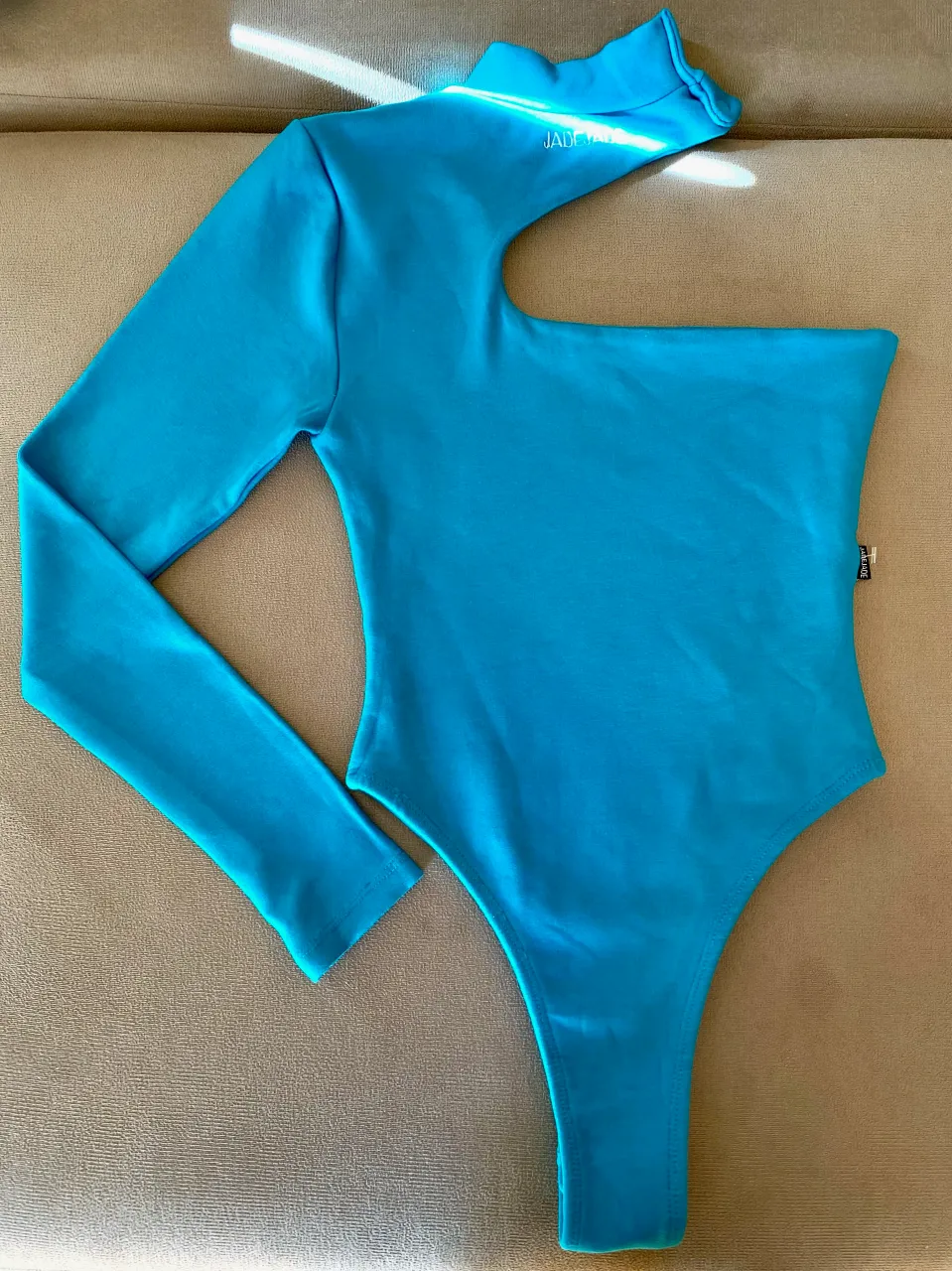 Body de manga larga y cuello alto, con un solo hombro descubierto. 
Tiene broches en la parte inferior y en el cuello.
Doble tela interior exterior, súper gruesito y abrigado