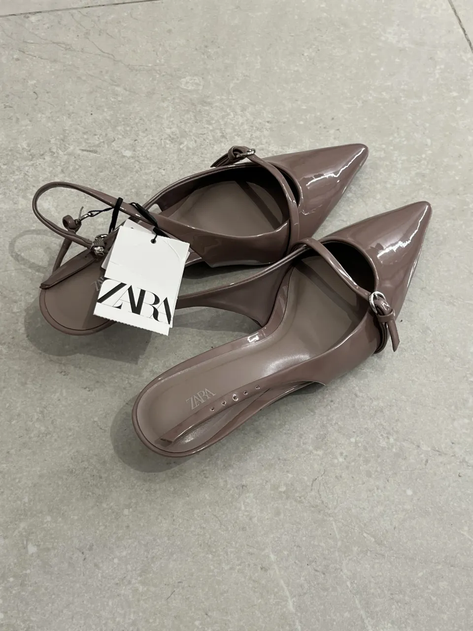 Zapatos de taco aguja color nude, con tiras finas y hebilla. 